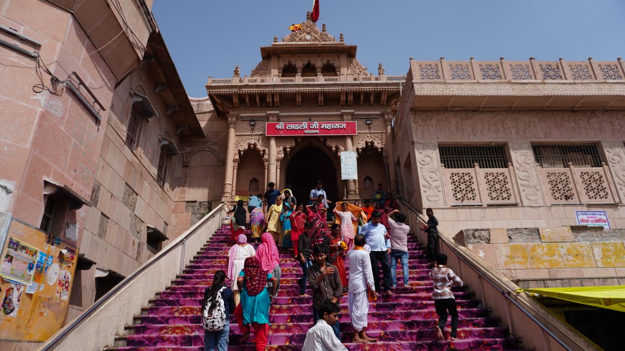 Offerings Pilgrims walking up the vibrant stairs of Shri Radha Rani Temple in Barsana, India.